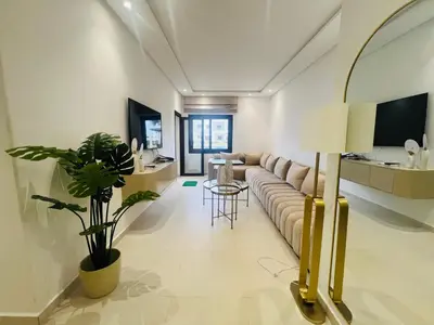 a living room with a couch and a table at Colina Smir par Immo Marina Vacances de Rêve D1-3 in Oulad Akkou