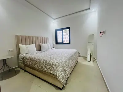 a bedroom with a large bed and a window at Colina Smir par Immo Marina Vacances de Rêve D1-3 in Oulad Akkou