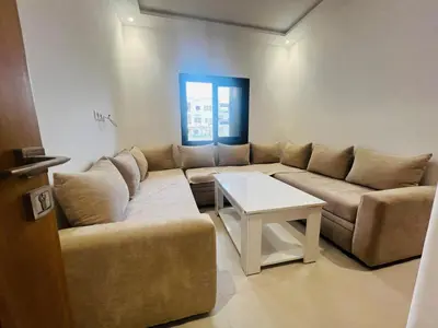 a living room with a couch and a table at Colina Smir par Immo Marina Vacances de Rêve D1-3 in Oulad Akkou