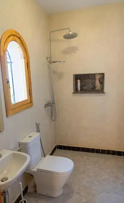 a bathroom with a white toilet and a sink at Najma Ourika in Ourika