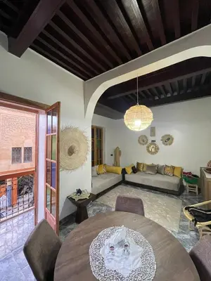 a living room with a table and a couch at Dar Ghita in Fès