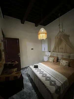 a bedroom with a large bed and a chandelier at Dar Ghita in Fès