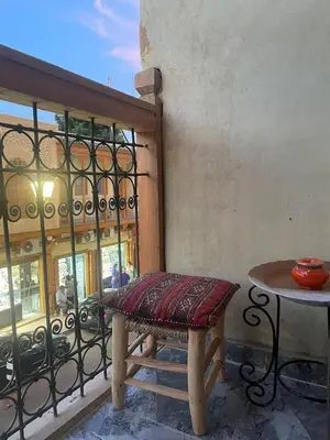 a bench sitting next to a table on a balcony at Dar Ghita in Fès