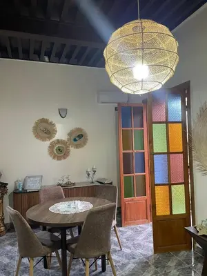 a room with a table and chairs and a colorful door at Dar Ghita in Fès