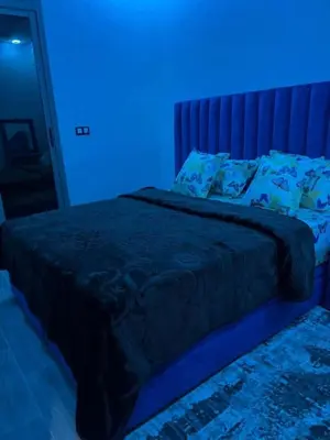 a bedroom with a bed with a blue light at Hote othmane in Beni Mellal