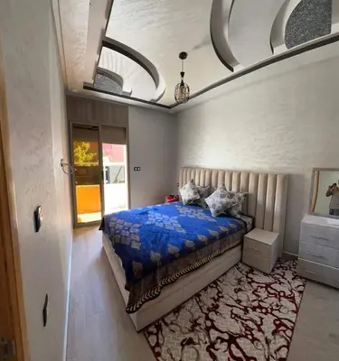 a bedroom with a bed with a blue comforter at Hote othmane in Beni Mellal
