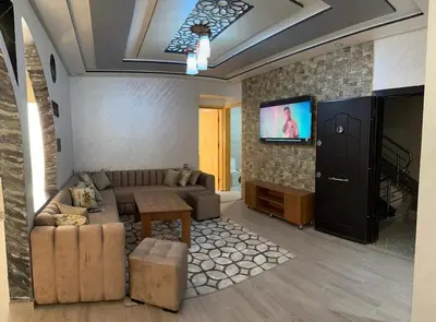 a living room with a couch and a tv at Hote othmane in Beni Mellal