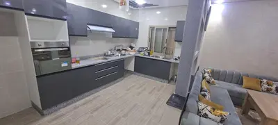 a kitchen with blue cabinets and a couch in a room at Hote othmane in Beni Mellal