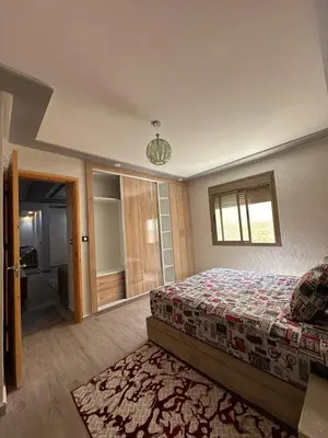 a bedroom with a bed and a sliding glass door at Hote othmane in Beni Mellal