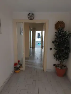 a hallway with a potted plant in a building at appartement meublé AGDAL 4chambre in Oulad Akkou