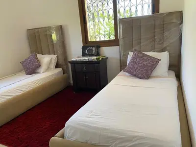 a room with two beds and a window at Campagne & Confort only family in El Hajeb