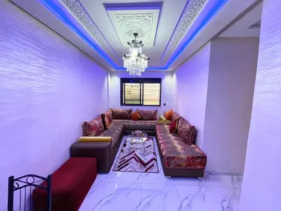 a living room with a couch and a chandelier at 2BR Luxurious Apartment - 2 Min from City Center in Fès