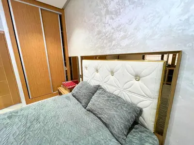 a bedroom with a bed with a large headboard at 2BR Luxurious Apartment - 2 Min from City Center in Fès