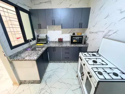 a small kitchen with a stove and a sink at 2BR Luxurious Apartment - 2 Min from City Center in Fès