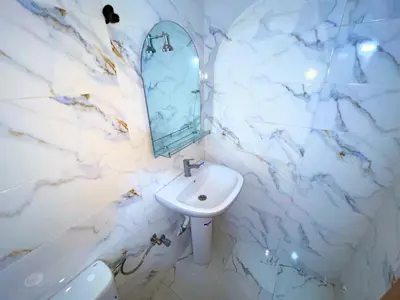 a white bathroom with a sink and a mirror at 2BR Luxurious Apartment - 2 Min from City Center in Fès