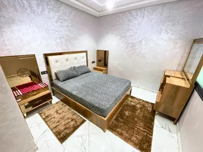 a bedroom with a bed and two night stands at 2BR Luxurious Apartment - 2 Min from City Center in Fès