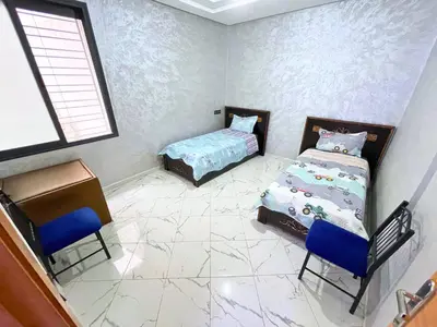 a bedroom with a bed and a table and chairs at 2BR Luxurious Apartment - 2 Min from City Center in Fès