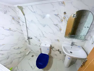 a bathroom with a sink and a toilet and a mirror at 2BR Luxurious Apartment - 2 Min from City Center in Fès