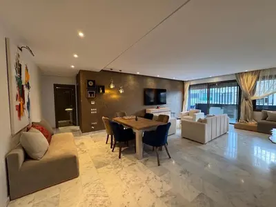 a large living room with a table and chairs at Luxury 3-Bedroom Apartment Near Marriott Fès in Fès