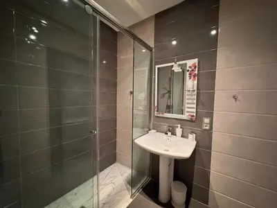 a bathroom with a sink and a glass shower at Luxury 3-Bedroom Apartment Near Marriott Fès in Fès