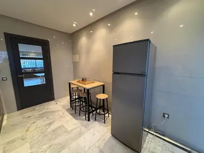 a kitchen with a small table and a refrigerator at Luxury 3-Bedroom Apartment Near Marriott Fès in Fès