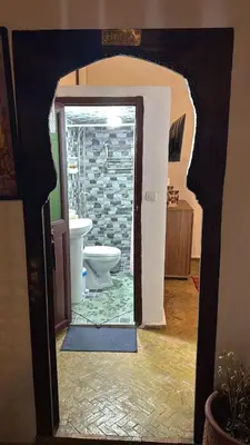 a bathroom with a toilet and a door open at Riad fezira in Fès