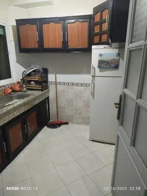 a kitchen with a refrigerator and a tile floor at Black iris tadamoune in Meknès