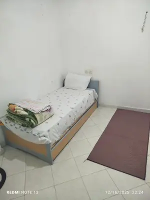 a small bed in a room with a tiled floor at Black iris tadamoune in Meknès