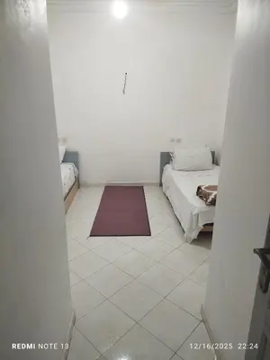 a bedroom with a bed and a rug on a tiled floor at Black iris tadamoune in Meknès