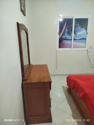a room with a bed and a wooden dresser at Black iris tadamoune in Meknès