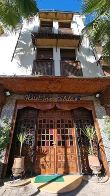 a front door of a building with palm trees in front at Hotel jnane sbille in Fès