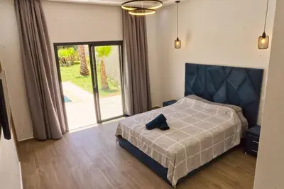 a bedroom with a bed and a large window at Bali family villa 0 vis-à-vis in Chouiter