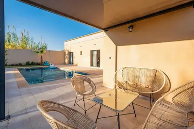 a patio with chairs and a table and a pool at Bali family villa 0 vis-à-vis in Chouiter