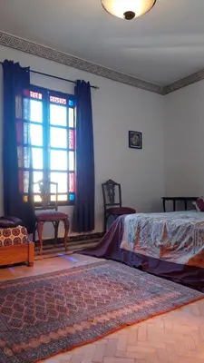 a bedroom with a bed and a window and a rug at JNANE RBATI Apartement in Fès