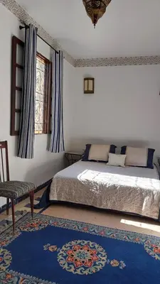 a bedroom with a bed and a chair at JNANE RBATI Apartement in Fès