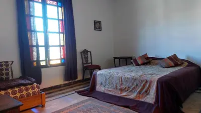 a bedroom with a bed and a large window at JNANE RBATI Apartement in Fès