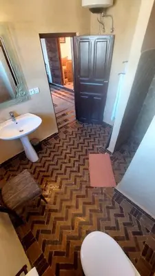a bathroom with a sink and a toilet and a mirror at JNANE RBATI Apartement in Fès