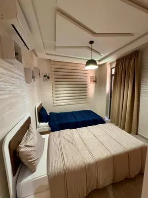 a bedroom with two beds and a couch in it at Gueliz Twin Balcony Apartment F3 in Oulad Akkou