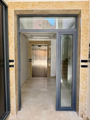 a hallway with a glass door in a building at Gueliz Twin Balcony Apartment F3 in Oulad Akkou