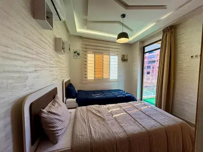 a small bedroom with a bed and a window at Gueliz Twin Balcony Apartment F3 in Oulad Akkou