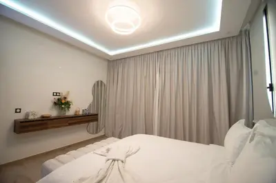 a bedroom with a white bed and a mirror at Somptueuse villa 10personnes in Najem