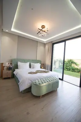a bedroom with a large bed with a green ottoman at Somptueuse villa 10personnes in Najem