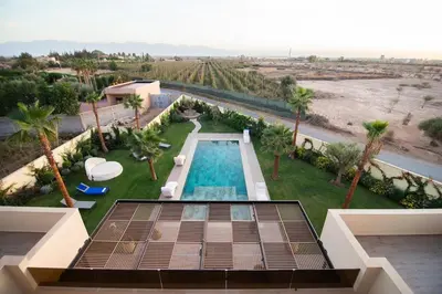 an aerial view of a resort with a swimming pool and palm trees at Somptueuse villa 10personnes in Najem
