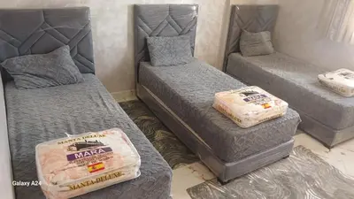 a room with three beds with mattresses at شقق الراحة in Oulad Akkou