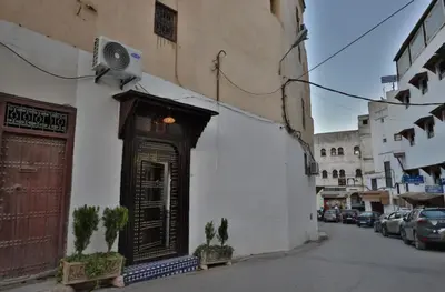 a building with a door on the side of a street at Fes flower in Fès