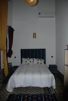 a bedroom with a large bed with a black headboard at Fes flower in Fès