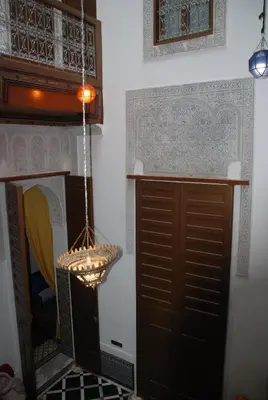 a chandelier hanging over a fireplace in a room at Fes flower in Fès