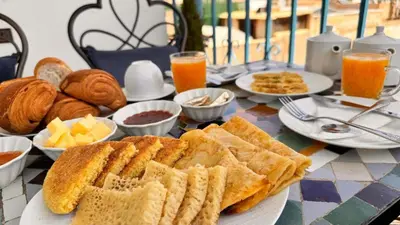 a table topped with plates of bread and orange juice at Fes flower in Fès