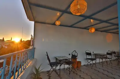 a patio with tables and chairs on a balcony at Fes flower in Fès