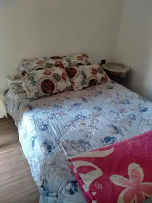 a bedroom with a bed with a flowered blanket and pillows at Apartment with Elevator Stadium and CHU within walking distance in Fès